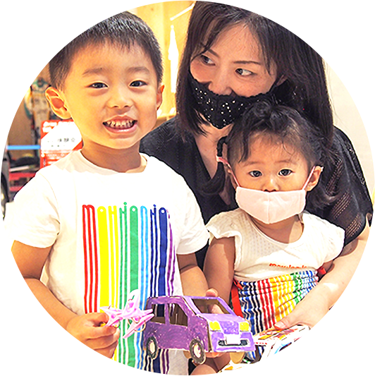 お母さんと子ども2人と笑顔でこちらを向いている様子